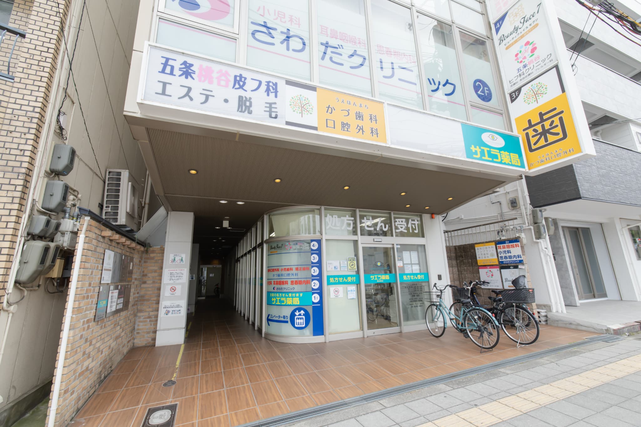 歯科・皮フ科・小児科・薬局などが入った医療ビルの入口と各院の看板